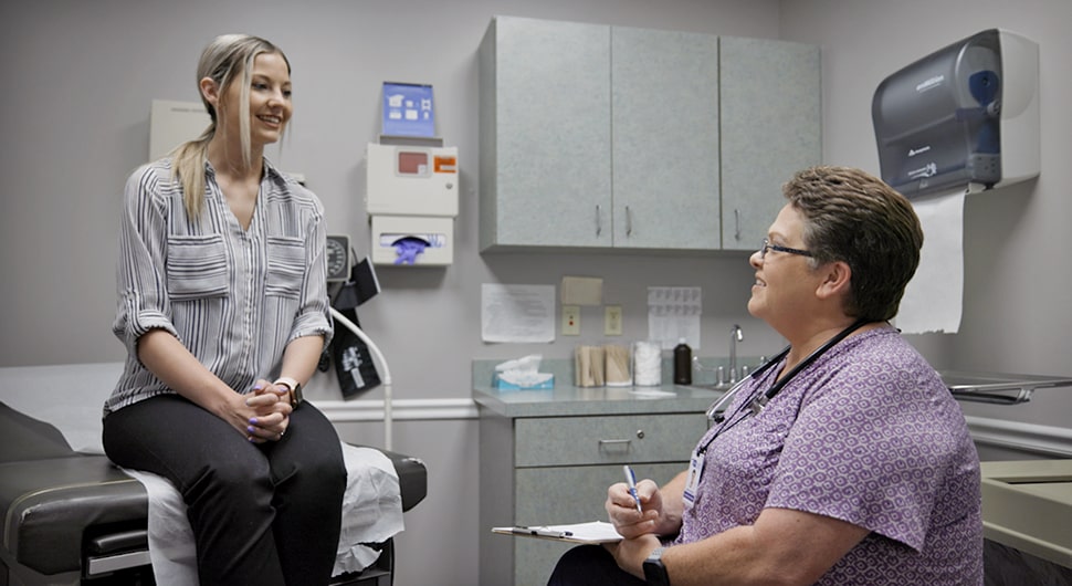 Patient seated in an exam room with a NeoHealth provider